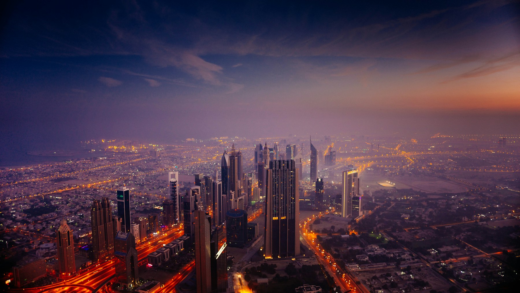 Verlichte skyline van Dubai bij zonsopkomst